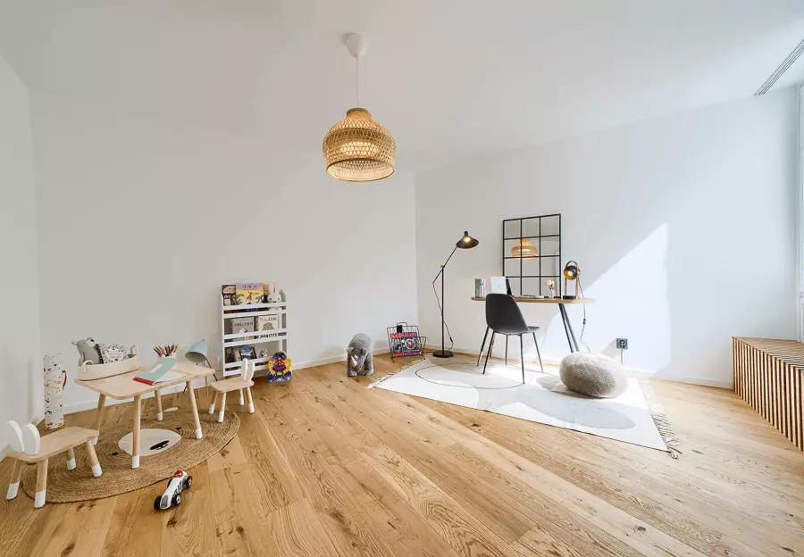 Freundliches Kinderzimmer in München mit Holzspielzeug, Schreibtisch und kreativer Beleuchtung, frisch saniert und einladend gestaltet.