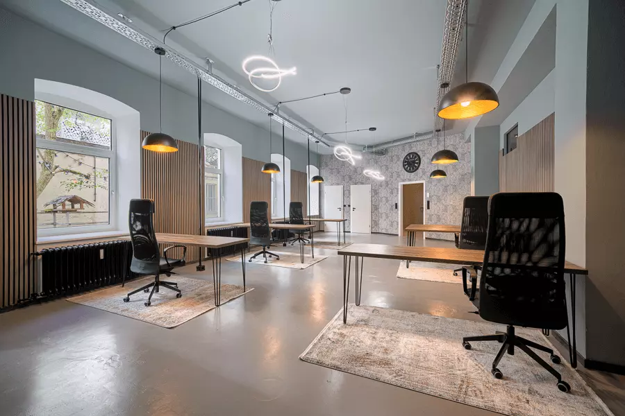 Stilvolles Büro mit Holzdesign, schwarzen Stühlen und einzigartiger Beleuchtung, nach Sanierung in München.