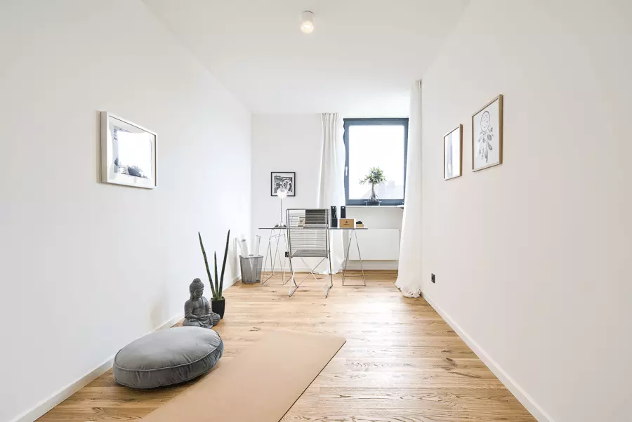 Schlichtes Arbeitszimmer mit Eichenparkett, weißer Wand und minimalistischer Einrichtung in einem frisch sanierten Münchner Heim.