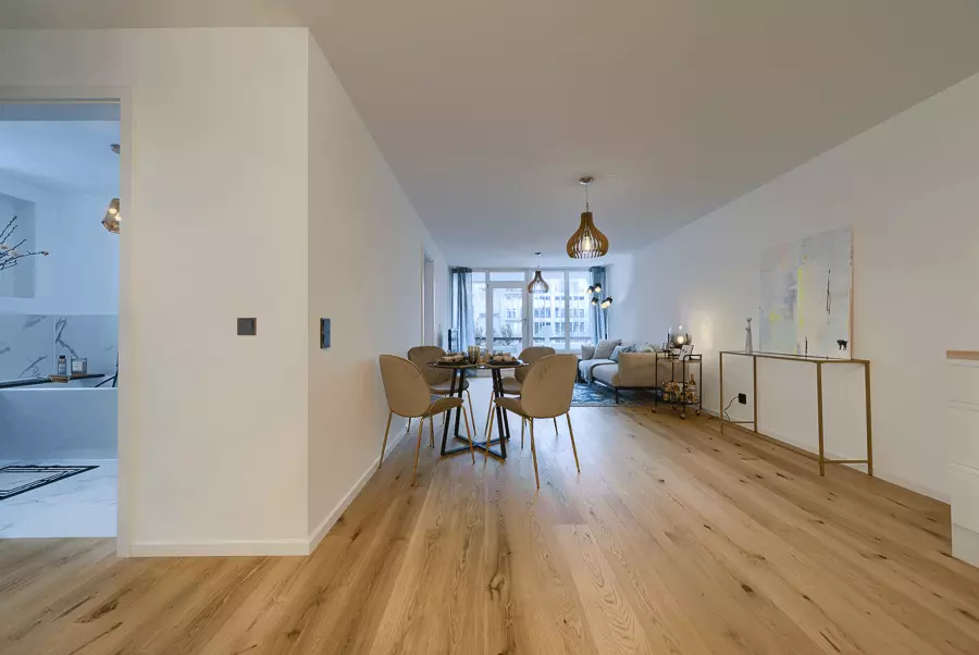 Heller, geräumiger Wohnbereich mit Holzboden und Designermöbeln, frisch renoviert in einem Münchner Apartment.
