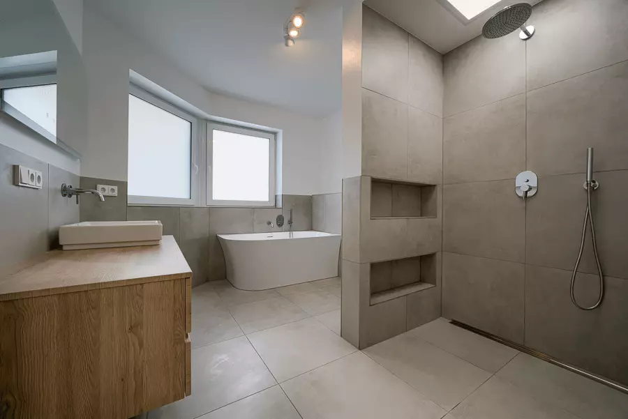 Stilvolles Badezimmer mit neutralen Farbtönen, Dachfenster und begehbarer Dusche, saniert für ein zeitgemäßes Wohnen in München.