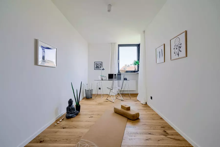 Renoviertes Home-Office in München mit weißer Wand, Eichenholzboden und moderner, minimalistischer Einrichtung, bereit für produktive Stunden.